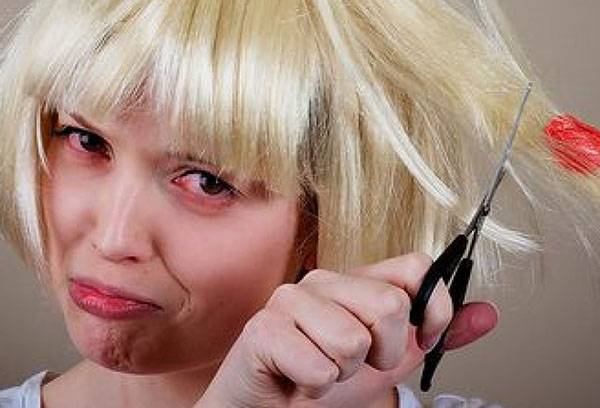 La ragazza taglia i capelli con la gomma da masticare