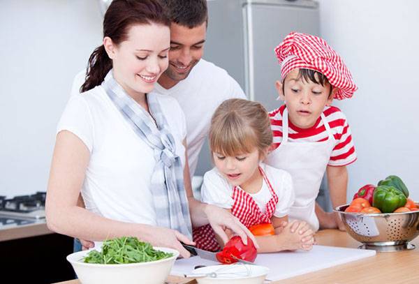 Famiglia in cucina a preparare un'insalata