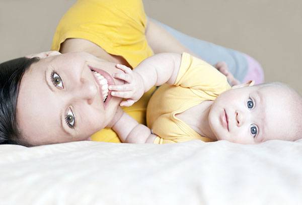 Mamma con un bambino su un letto senza cuscino