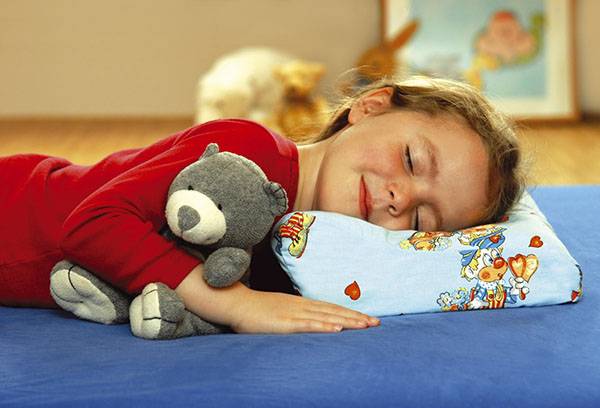 Ragazza che dorme su un cuscino ortopedico