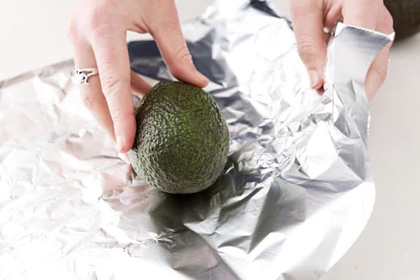 La donna avvolge avocado in un foglio