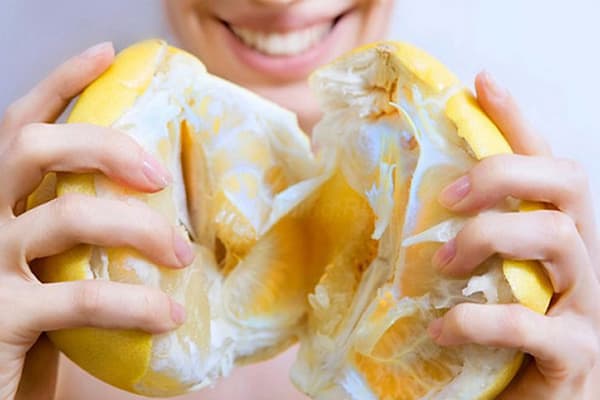 Ragazza con un pomelo maturo