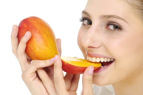 Ragazza che mangia mango