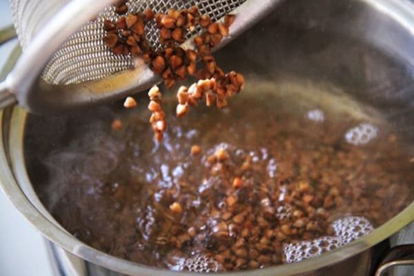 Aggiungendo grano saraceno lavato alla padella