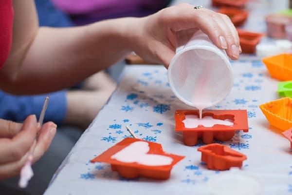 Woman pours soap in a mold