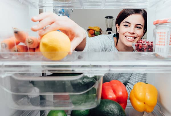 La ragazza mette il limone in frigo