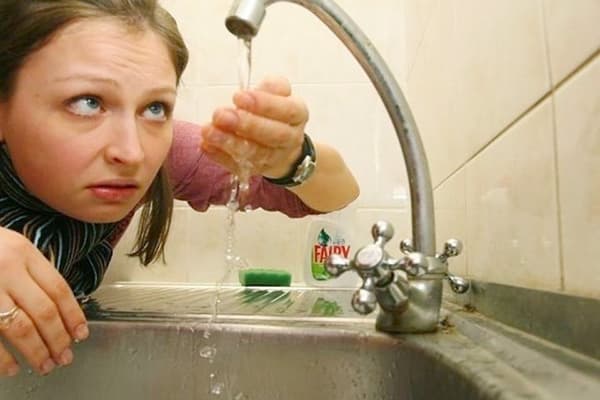 La donna esamina l'acqua del rubinetto