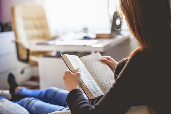 La ragazza legge un libro a casa