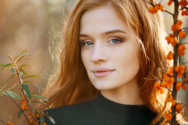 Ragazza accanto a un cespuglio di olivello spinoso