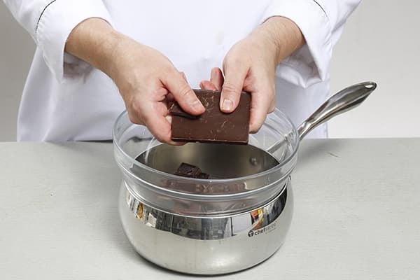 Il pasticcere annega il cioccolato a bagnomaria